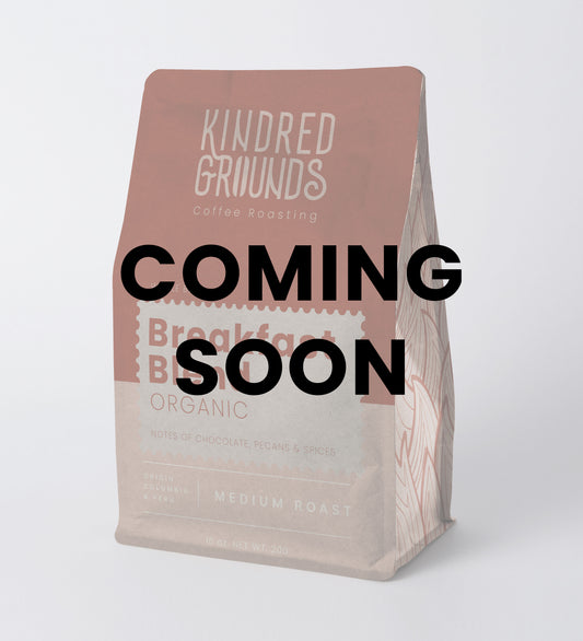 Coffee bag with 'Kindred Grounds' branding and 'Coming Soon' text on a white background